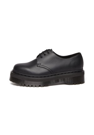 Zwart leren veterschoen met een ronde neus, dikke zwart rubberen platformzool en textuurdetails op de buitenzool.