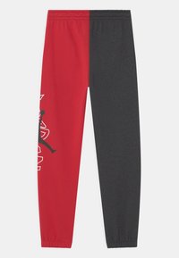 Czerwono-czarne spodnie dresowe z elastycznym paskiem w talii, zwężanymi nogawkami oraz graficzną sylwetką po czerwonej stronie. Wykonane z miękkiej mieszanki bawełny.