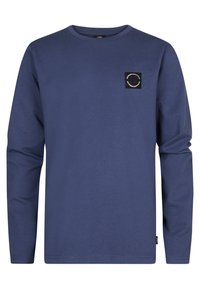 Maglietta a maniche lunghe blu navy con collo rotondo, dotata di una piccola toppa nera a forma di quadrato sulla parte sinistra del petto.