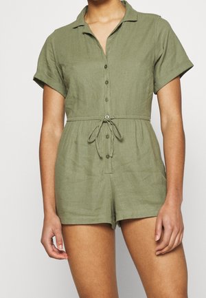 Combinaison en lin vert olive à manches courtes, col, boutonnage sur le devant et ceinture à la taille. Caractérisée par une coupe décontractée et un détail de texture.