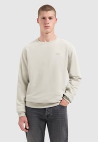 Helles graues Sweatshirt aus weichem Material mit gerippten Bündchen und Saum. Verfügt über ein kleines "PURE PATH"-Logo, das auf der Brust gedruckt ist. Lässiger Schnitt.
