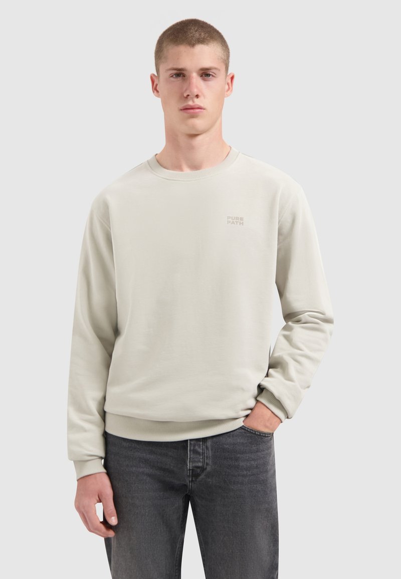 Helles graues Sweatshirt aus weichem Material mit gerippten Bündchen und Saum. Verfügt über ein kleines "PURE PATH"-Logo, das auf der Brust gedruckt ist. Lässiger Schnitt.