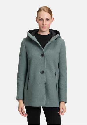 Grüner Fleece-Hoodie mit texturiertem Finish, ausgestattet mit einer Reißverschlusstasche, Knopfverschluss und einem kontrastierenden schwarzen Futter.