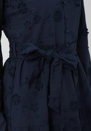Robe bleu marine avec broderies florales, dotée d'une ceinture nouée à la taille et de boutons sur le devant, fabriquée en tissu doux avec des détails texturés.