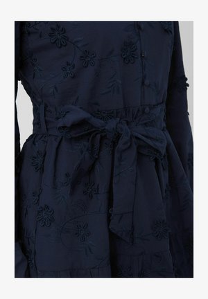 Robe bleu marine avec broderies florales, dotée d'une ceinture nouée à la taille et de boutons sur le devant, fabriquée en tissu doux avec des détails texturés.