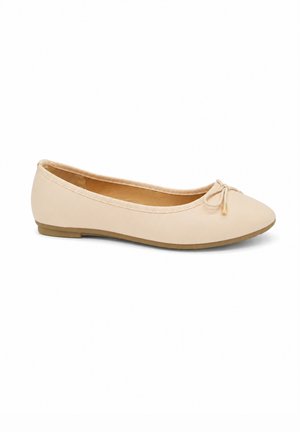 Chaussure plate de ballet beige avec un petit nœud sur l'orteil arrondi et une semelle plate, vue de côté sur fond blanc.