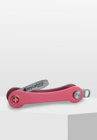 Rosa multitool med en elegant metalldesign, som har en silver nyckelringfäste och ett vitt schweiziskt korsemblem på en rundad ände.