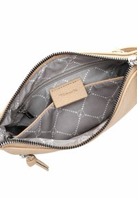 Beige läderväska inuti med silverdragkedja, grå foder och ett geometriskt mönster. Har ett innerfack med dragkedja och en liten etikett.