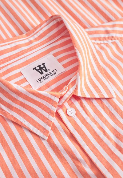Collar and top button of a pink and white striped shirt with a label reading "Double A by Wood Wood" inside the collar.
