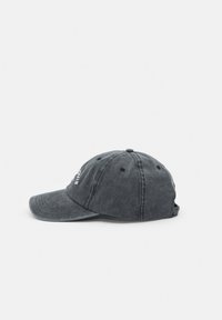 Casquette de baseball en coton gris foncé avec visière incurvée et texte brodé sur le devant, vue de profil sur un fond clair.