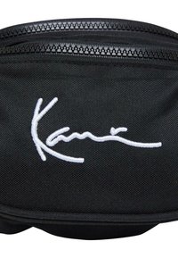 Zwarte stoffen pouch met een witte geborduurde handtekening. Het heeft een soepele ritssluiting en een duurzame, gestructureerde oppervlakte.