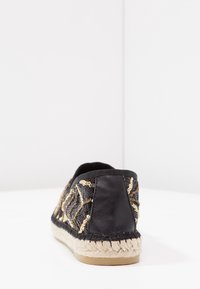 Czarne espadryle z teksturowanej tkaniny z ozdobnym wzorem z złotych cekinów, pleciona podeszwa z juty oraz zaokrąglony czubek.