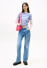 Blauw-wit gestreepte lange mouw top, hoog-waisted lichte blauwe jeans, zwarte plateauschoenen en een kleine roze schoudertas.