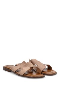 Sandalias planas de tela marrón con un diseño abierto, que cuentan con dos tiras anchas y una plantilla de cuero marrón. Construcción simple y discreta.