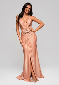 Formelles roségoldenes Kleid mit tiefem Ausschnitt, drapierter Stoff, florale Akzentuierung an der Taille und einem hohen Schlitz bis zum Oberschenkel. Glatte, glänzende Textur.