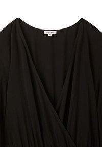 Abito nero con scollatura a V profonda e tessuto drappeggiato. Etichetta con la scritta "Terranova" in taglia XL/XXL. Texture liscia, dettagli minimi.