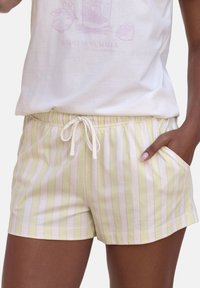 Hellgrüne und weiße gestreifte Shorts mit weicher Textur, elastischem Bund mit Kordelzug und seitlichen Taschen.