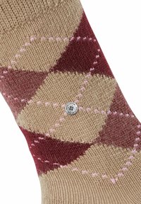 Calze in maglia nei colori beige, bordeaux e rosa con motivo argyle, caratterizzate da un tessuto testurizzato e un piccolo tag metallico con il marchio.