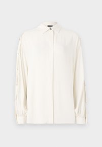 Blusa bianca a maniche lunghe con colletto, chiusura a bottoni e polsini arricciati. Presenta bottoni decorativi lungo le maniche. Tessuto liscio.