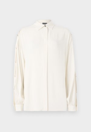White long-sleeve blouse with a collared neck, button front, and gathered cuffs. Features decorative buttons along the sleeves. Smooth texture.