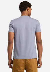 Lys blå kortærmet t-shirt med rund hals og glat tekstur, med et ensfarvet design og lige kant ved taljen.