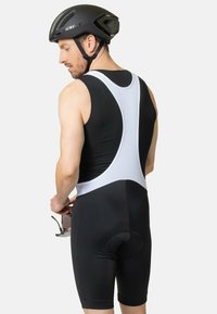 Cuissards de vélo noirs et blancs avec un design ajusté, comprenant un dos en maille, une assise rembourrée et des ouvertures de jambe élégantes. Comprend des lunettes de soleil.