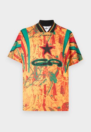 Kortermet skjorte med svart krage, med et mønster av lyse oransje og grønne blader, røde detaljer og en stor logo på forsiden.