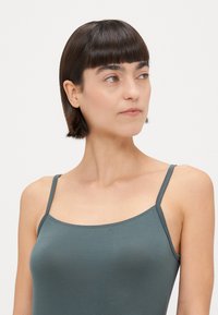 Grijs, aansluitend tanktop met dunne bandjes en een ronde halslijn, gemaakt van een soepele, zachte stof met minimale naden.