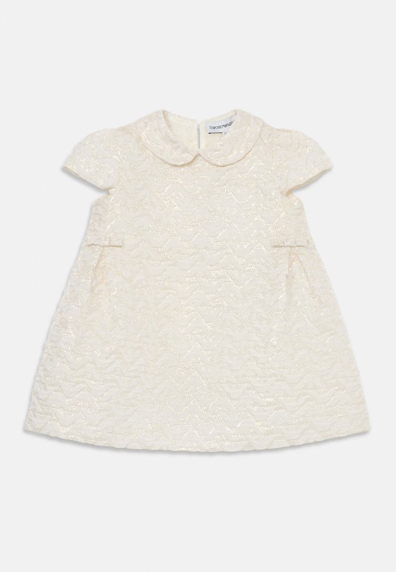 Vaalean kermaista mekkoa, jossa on tekstuuri aaltoileva kuvio, lyhyet hihat ja Peter Pan -kaulus. Mekossa on sivutaskut ja takakuvitus.