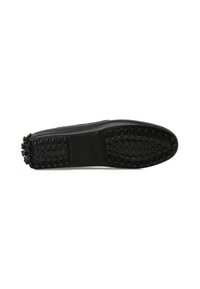 Suela de zapato de cuero negro con una superficie texturizada y puntos de goma circulares para agarre y un borde liso. Diseñada sin adornos adicionales.