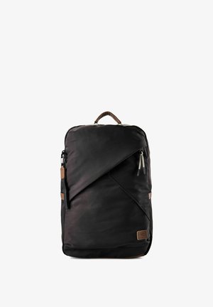 Mochila rectangular negra con bolsillo frontal diagonal, tiradores de cremallera de cuerda, asa marrón y parche de logo de cuero en la esquina inferior.