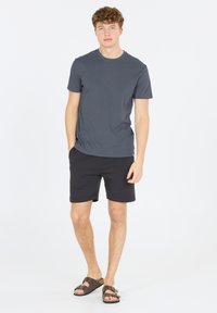 Mörkgrå t-shirt för män, svarta shorts och bruna sandaler. T-shirten har rund hals, shorts med elastisk midja och slät textur.