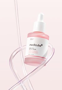 Siero Peptidico Pink PDRN di Medicube in una bottiglia di vetro rosa. Presenta un tappo contagocce bianco, un'etichetta bianca con accenti rosa e uno sfondo translucido.