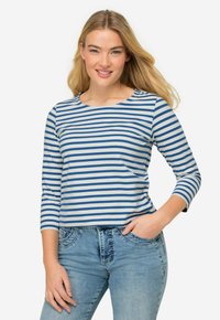 Blå och vitrandig långärmad t-shirt med rund halsringning. Mjukt tyg och en avslappnad passform, kombinerad med ljusblå jeans.