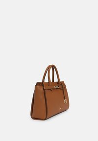 Bolso de mano de cuero marrón con una forma estructurada, doble asa, herrajes dorados y un llavero decorativo. Presenta costuras de acento en negro.