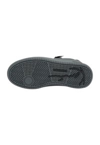 Black sneaker sole with textured zigzag and grid patterns, circular grip, and a stylized swoosh-like design on a plain white background.