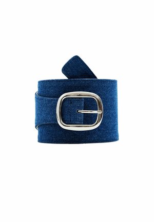 Ceinture en denim bleu roulée avec une boucle carrée argentée sur fond blanc.