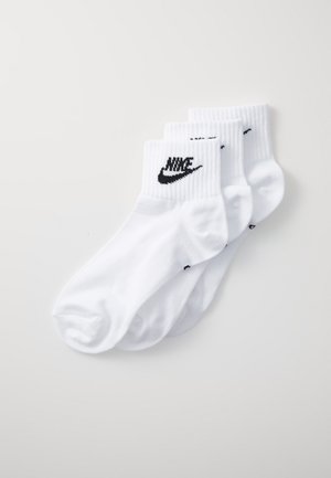 Tres pares de calcetines de algodón blanco tipo crew, con un puño acanalado y un logo de Nike negro en los laterales. Textura suave y diseño clásico.