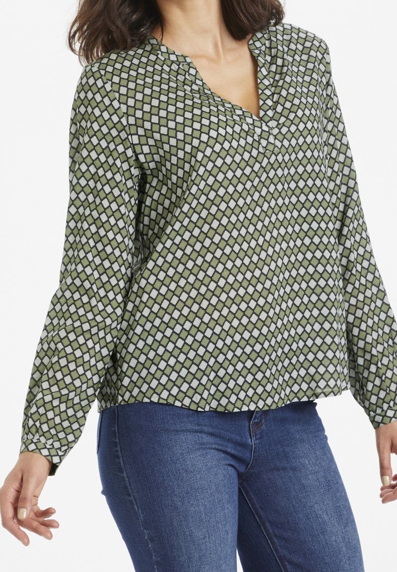 Grønt mønstret bluse med et diamantdesign i hvid. Letvægtsstof, V-hals og lange ærmer med en afslappet pasform.