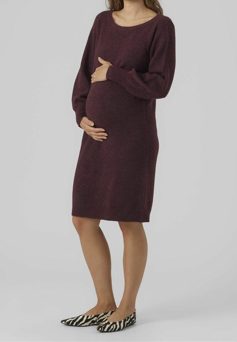 Robe de maternité tricotée bordeaux à manches longues, décolleté arrondi et ourlet côtelé. Associée à des ballerines à motif zèbre noir et blanc.