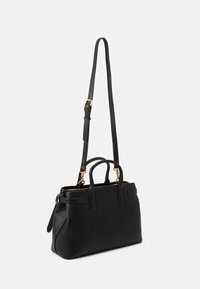 Czarna skórzana torebka o chropowatej fakturze, z podwójnymi uchwytami, odczepianym paskiem, złotymi akcentami i zamknięciem na zamek.