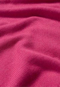 Fuchsia knit fabric with a smooth texture, featuring fine, even stitches and gentle draping, highlighting the richness of the color.