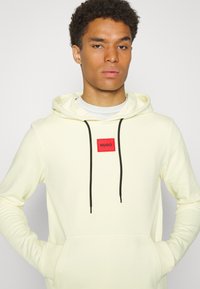 HUGO DARATSCHI - Sweatshirt com capuz - light pastel yellow