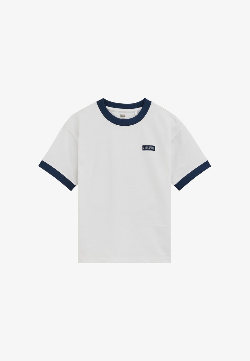 Bijela majica kratkih rukava s tamnoplavim ovratnikom i rubovima rukava, s malom tamnoplavom zakrpom s bijelim tekstom na lijevoj strani prsa.