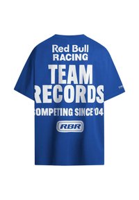 Mėlynas medvilninis marškinėlis su dideliu baltu tekstu: "Red Bull Racing KOMANDOS ĮRAŠAI DALYVAUJANČIOS NUO 04" su RBR logotipu apačioje. Įprasto modelio dizainas.