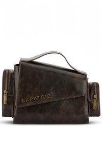Brun läderaxelväska med en strukturerad form, utrustad med en framvikt klaff, ett övre handtag och sidofickor med dragkedja. Gyllene "EXPATRIE" logotyp.