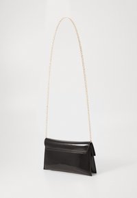 Clutch en cuir verni noir avec une chaîne dorée. Dispose d'une fermeture à rabat et d'une forme rectangulaire. Texture lisse avec un minimum de détails.
