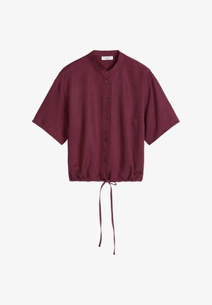 Blouse bordeaux à manches courtes avec boutons sur le devant, col rond, coupe ample et ourlet ajustable avec cordon de serrage.