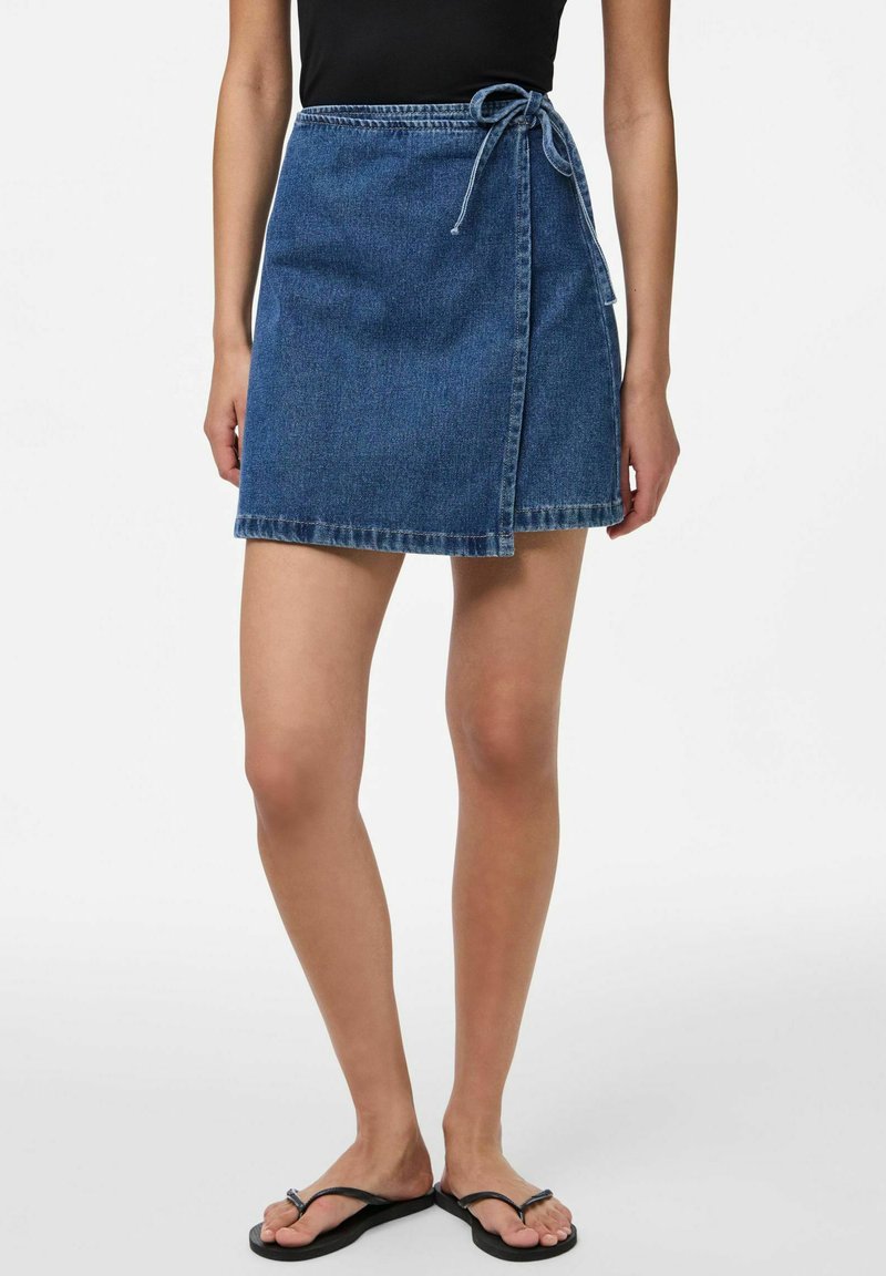 Tummansininen farkkukietaisuhame, jossa on solmittava vyö. Siinä on sinnikkäät reunat, A-linjainen muoto ja keskipainoinen kangas.