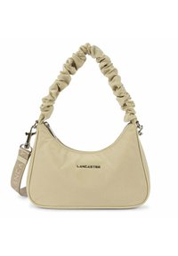 Sac à épaule en tissu beige avec une anse froncée, quincaillerie en acier inoxydable et logo "LANCASTER" en relief à l'avant. Forme lisse et arrondie.